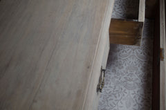 Wooden wardrobe with a partially open door revealing patterned wallpaper.