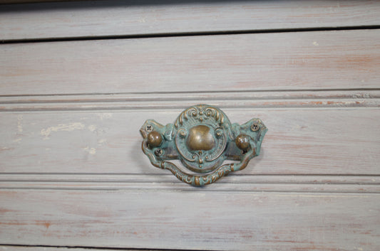 Decorative metal handle on a wooden surface