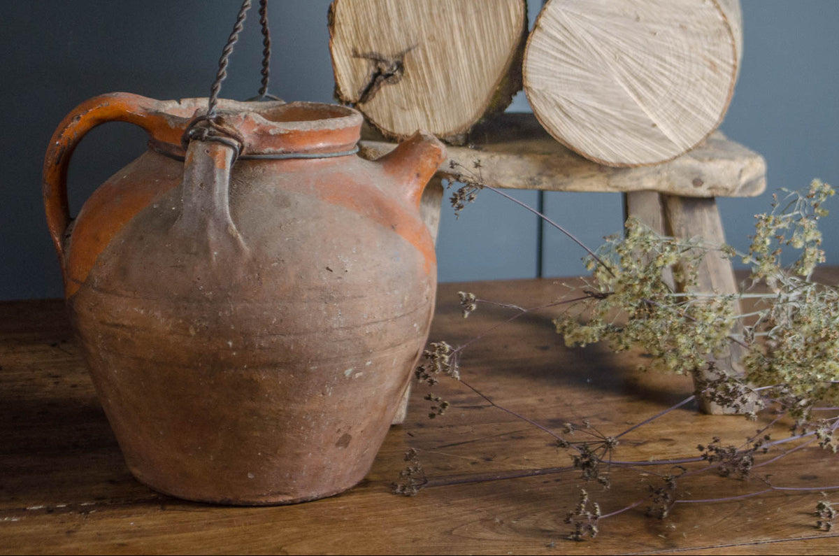 Old French terracotta oil jug with wire handle