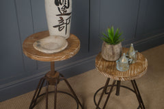 Two small wooden stools with decorative items against a dark blue wall.