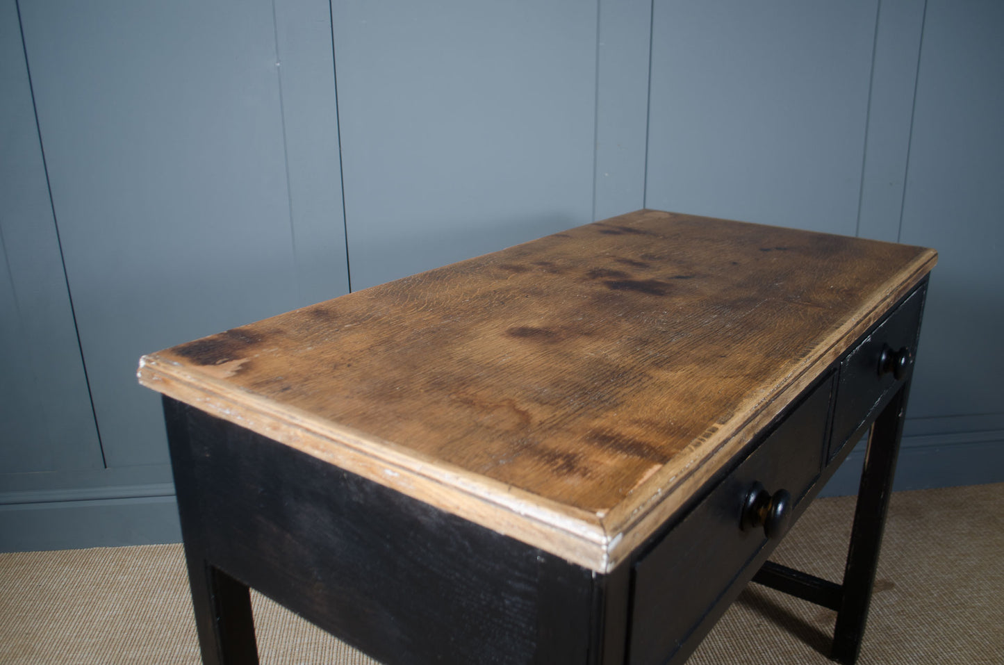 Vintage wooden desk against a blue paneled wall