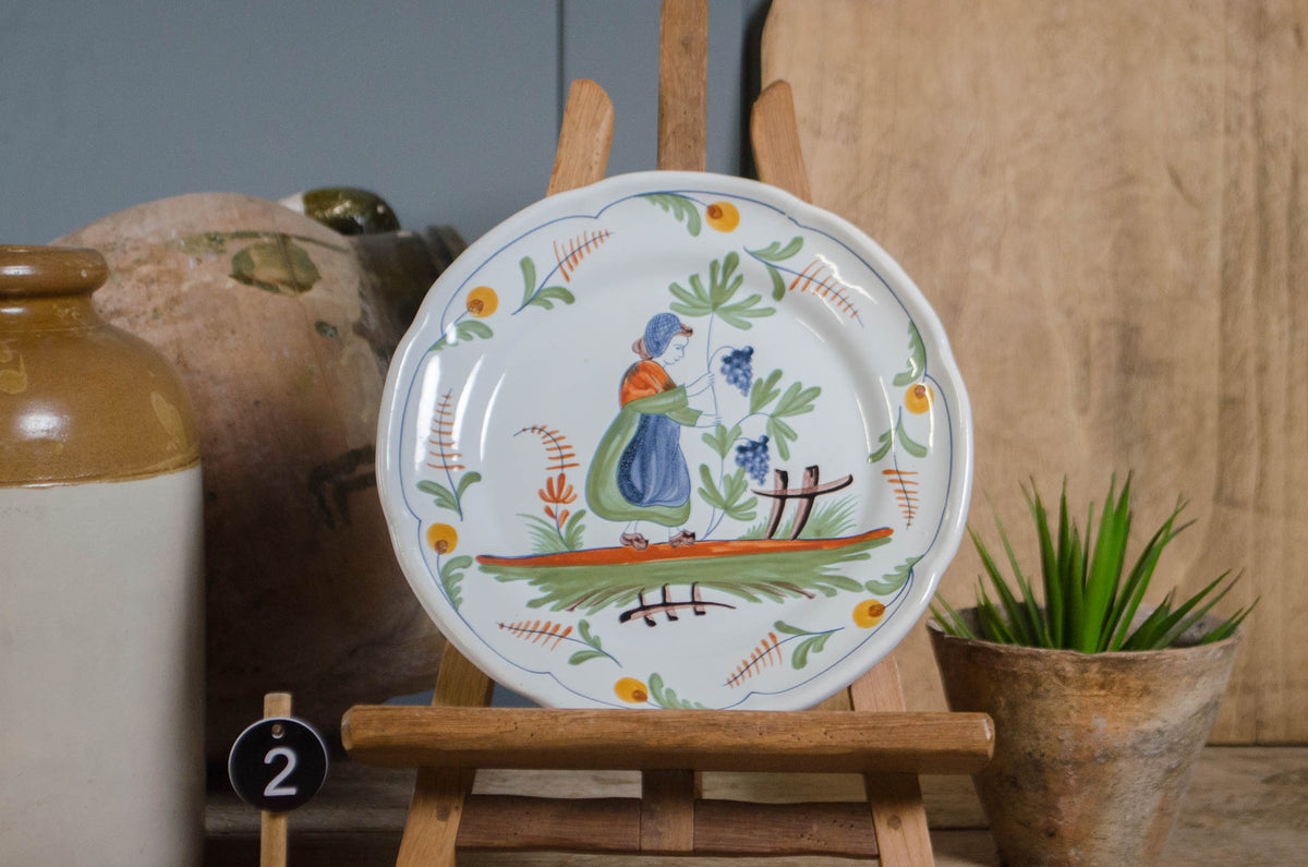 Vintage and antique French Quimper pottery plates displayed on dresser
