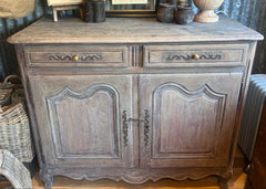 Antique French walnut sideboard with a soft lime washed finish, carved drawer and door detailing, original brass fittings, and a removable interior shelf inside the cupboard.