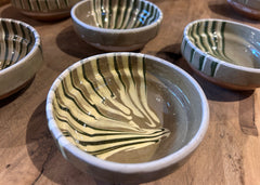 Small handcrafted ceramic bowls with green marble glaze and taupe interior, traditional Romanian pottery.