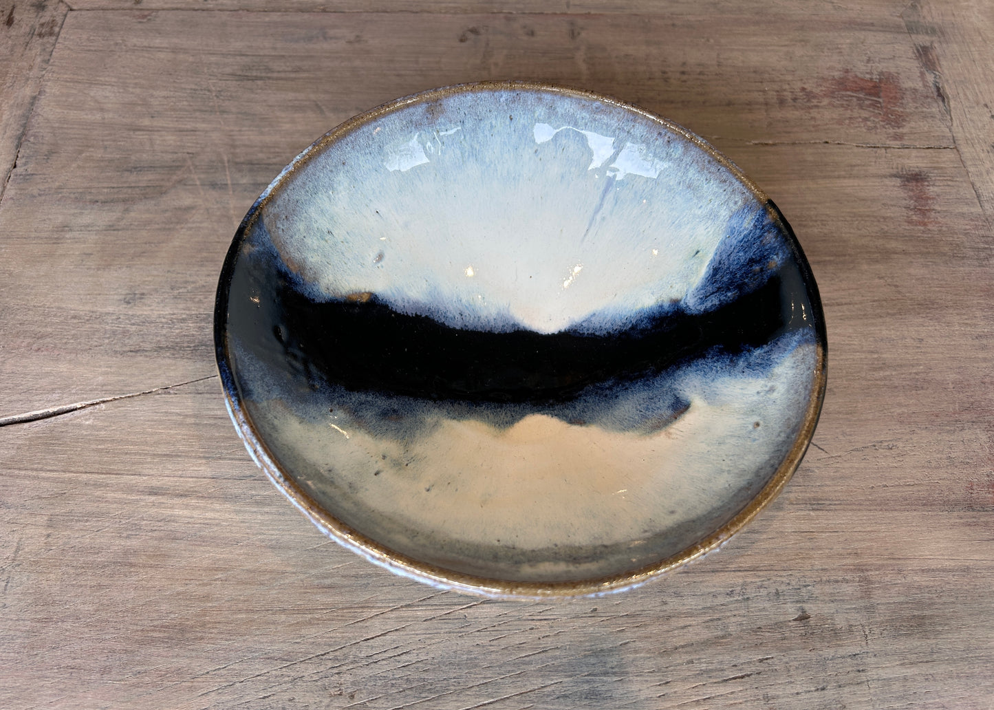 blue and white studio pottery bowl on bleached oak table
