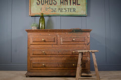 Vintage wooden dresser with a green bottle on a gray wall background