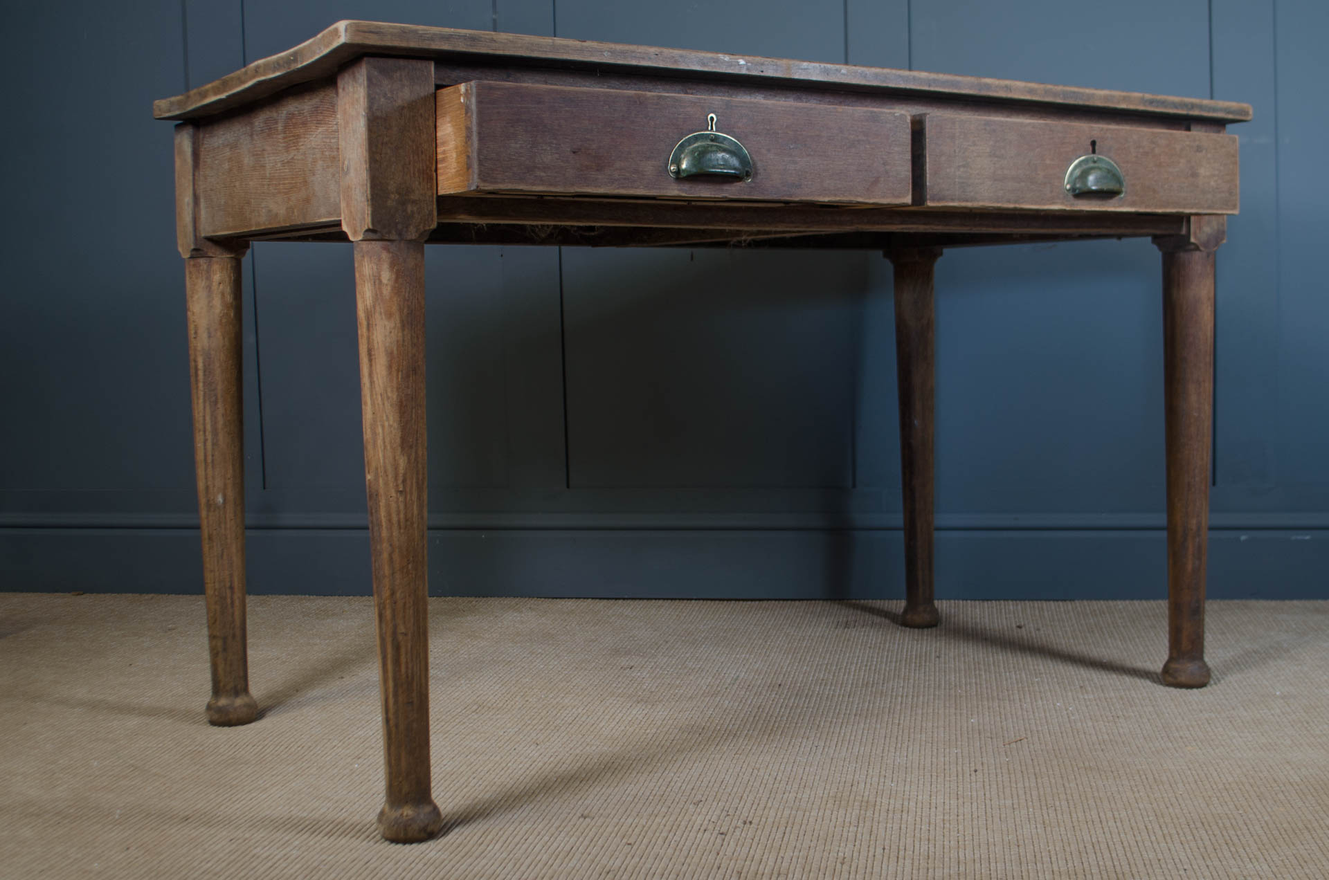 
English oak desk with brass cup pulls and slim turned legs