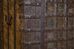 Close-up of a rustic wooden door with metal accents