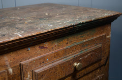 Vintage wooden dresser with chipped paint against a blue wall