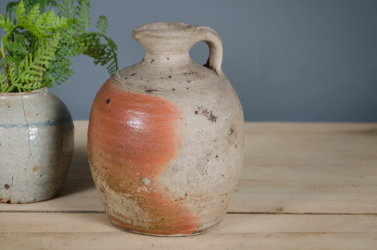 Antique French stoneware vinegar jar with handle and warm cream and terracotta glaze.
