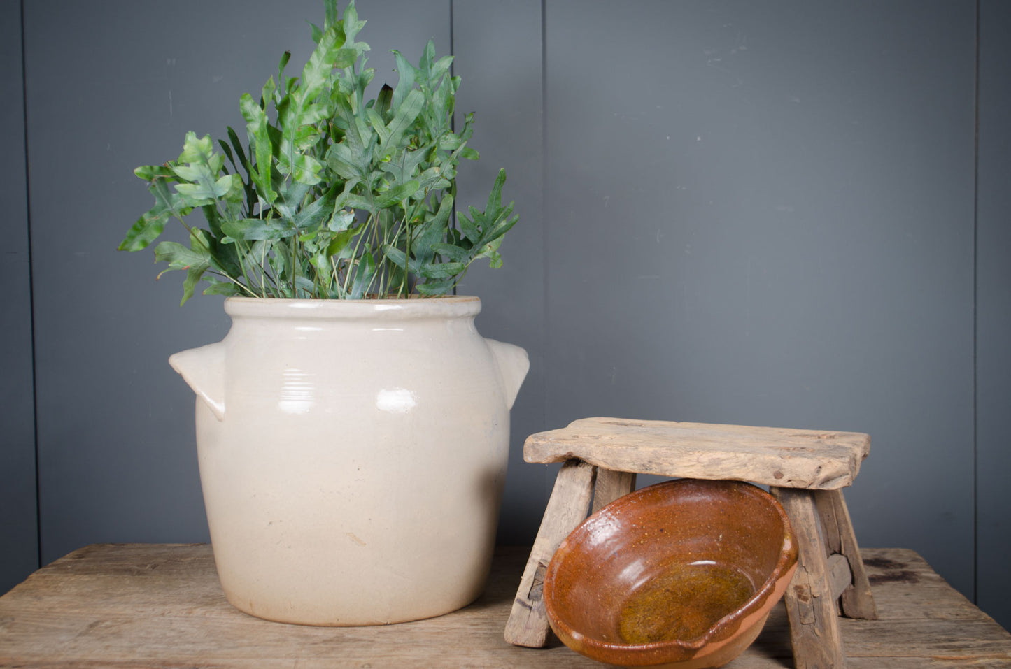Large French grey glazed stoneware confit jar with traditional side handles and drainage hole, suitable as a decorative planter.