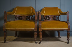 Pair of vintage wooden chairs with mustard yellow cushions against a blue wall.