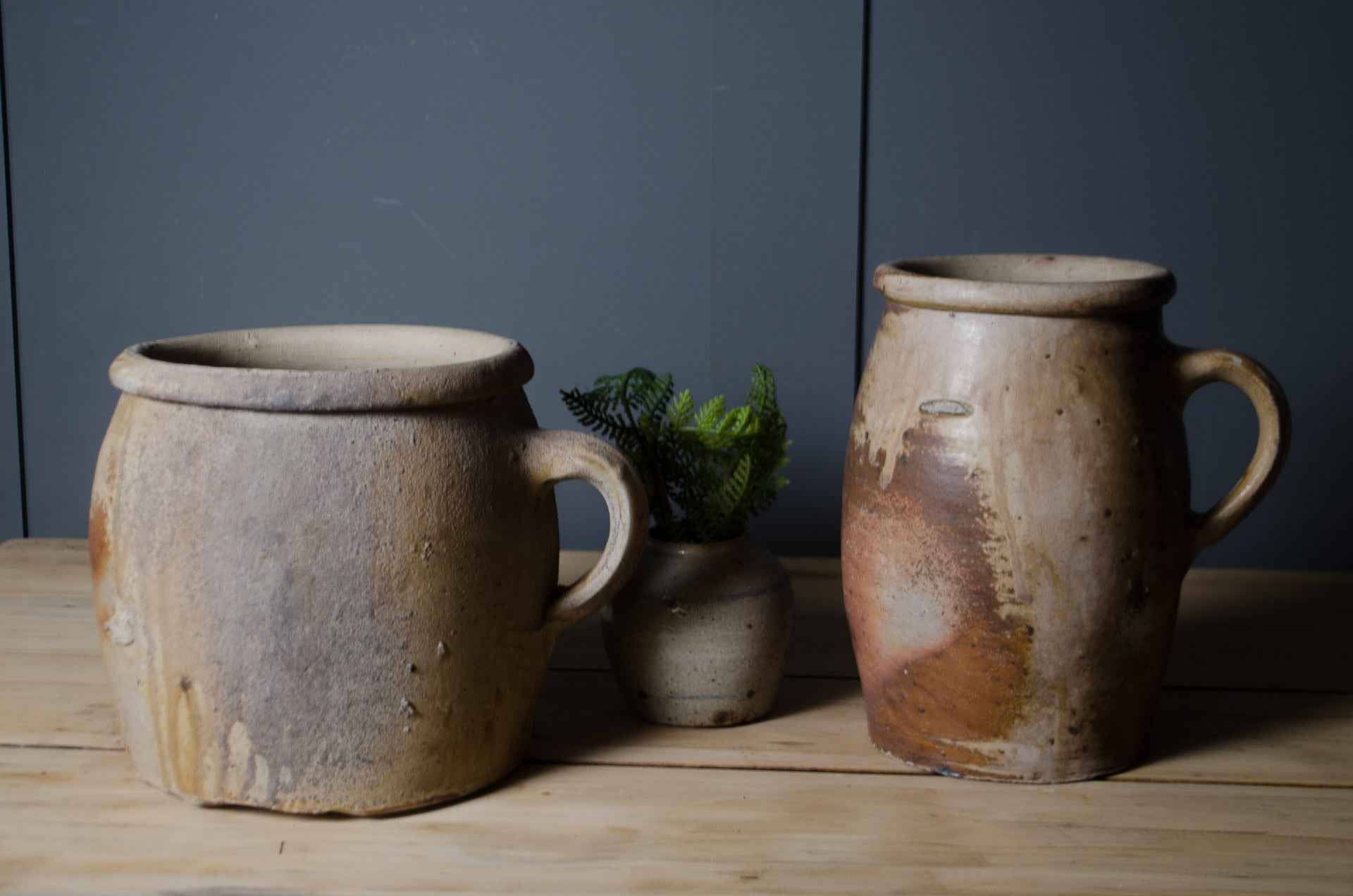 
Pair of antique French confit pots with rustic stoneware glaze and original handles.