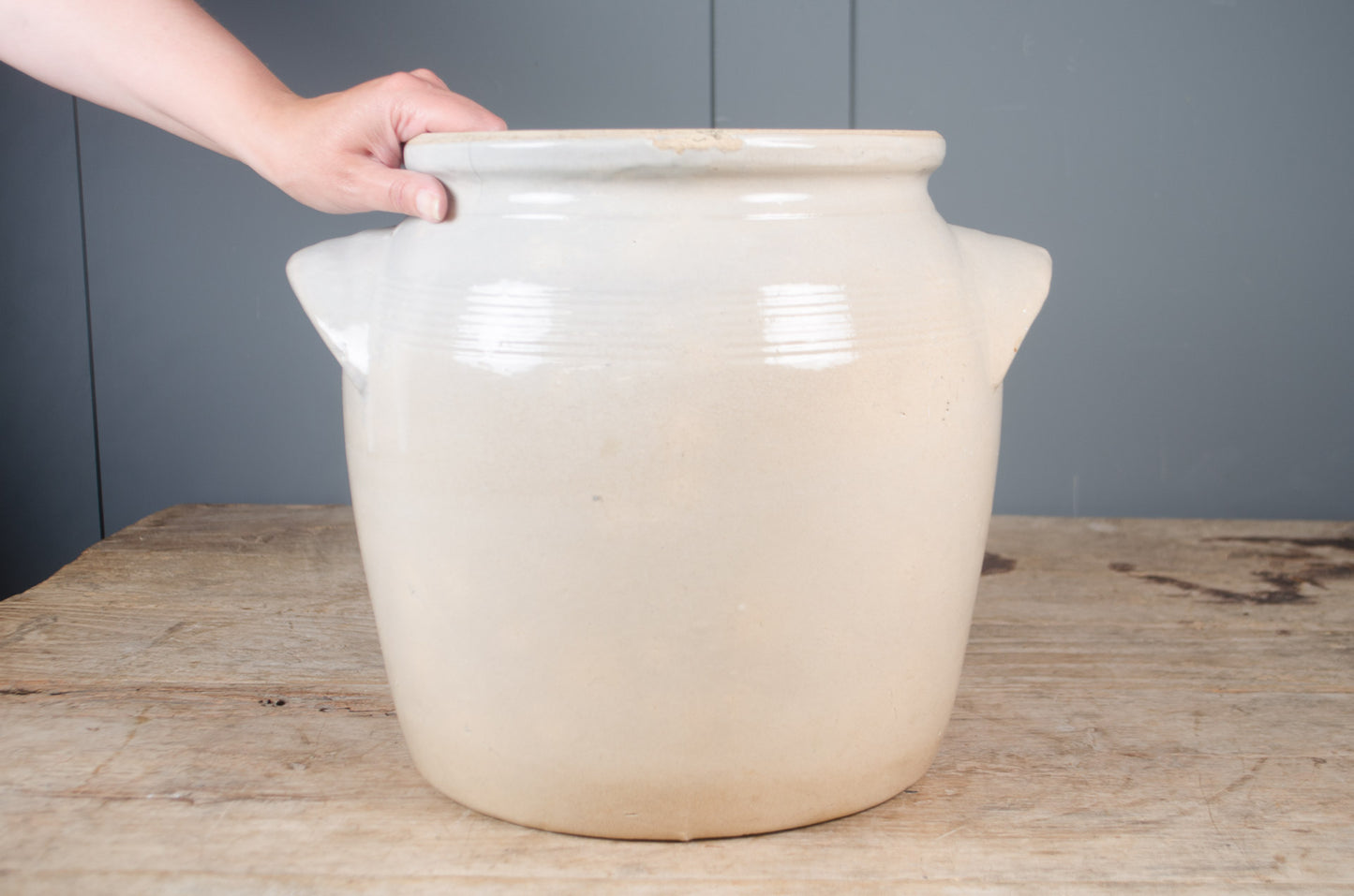 Large French grey glazed stoneware confit jar with traditional side handles and drainage hole, suitable as a decorative planter.