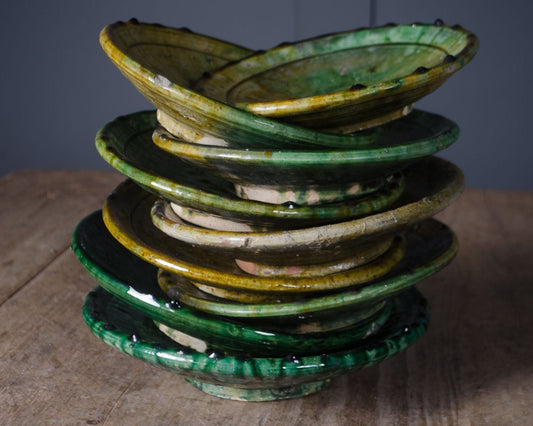 Moroccan Tamegroute ceramic plates with traditional green glaze stacked together.