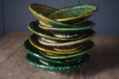 Moroccan Tamegroute ceramic plates with traditional green glaze stacked together.