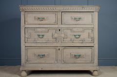 Vintage-style dresser with multiple drawers against a blue wall. in bleached oak finish
