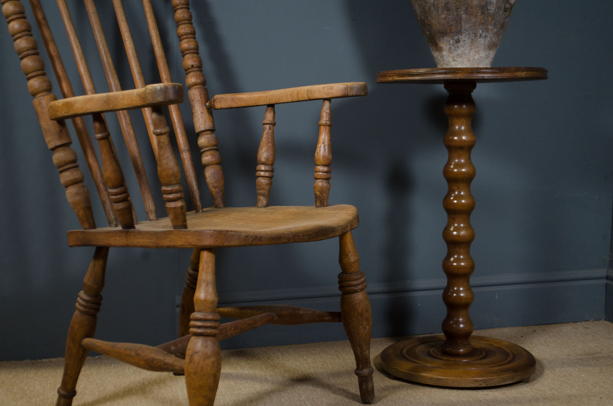 Vintage French pedestal side table beside wooden armchair