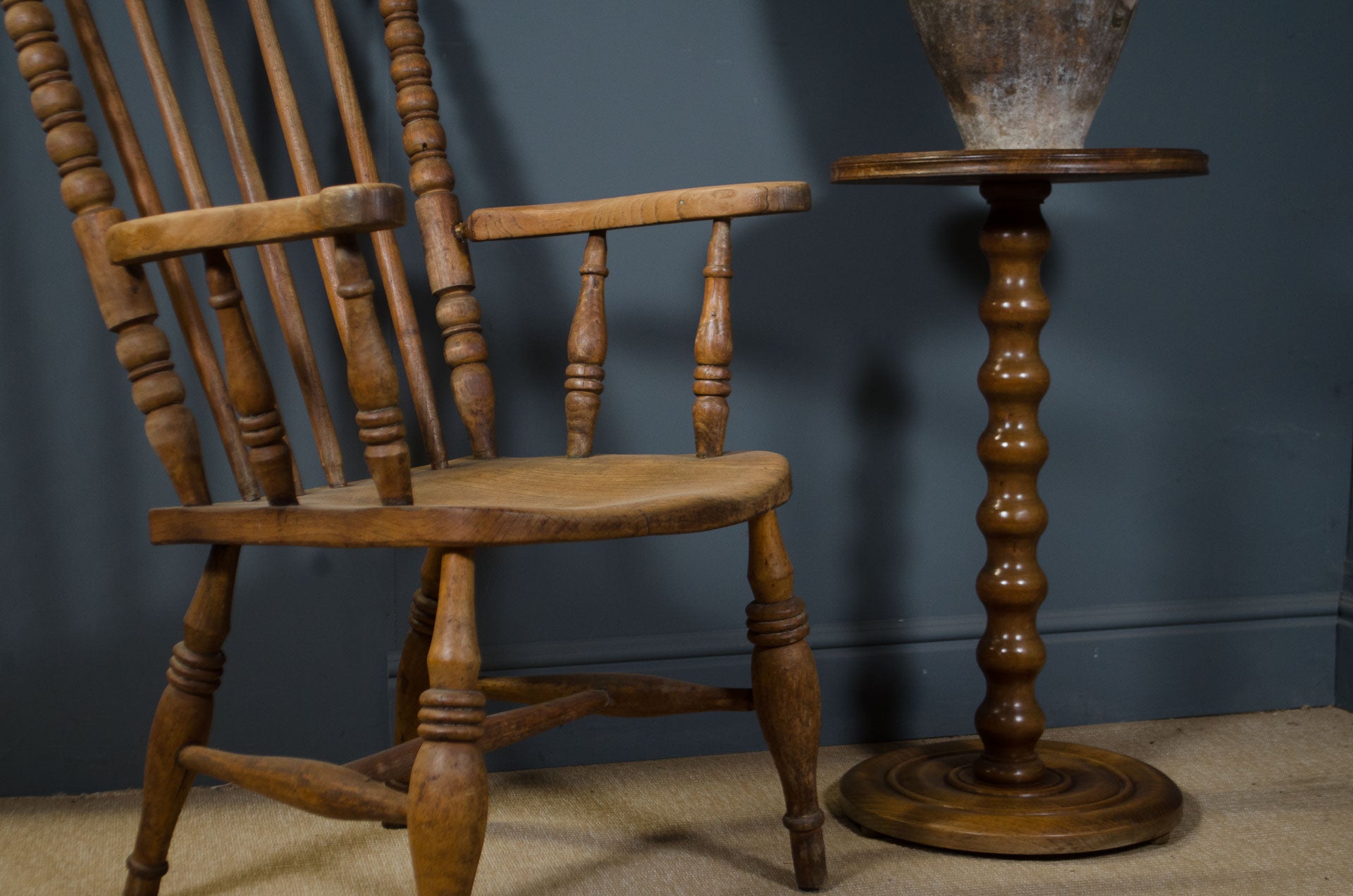 
Vintage French pedestal side table beside wooden armchair