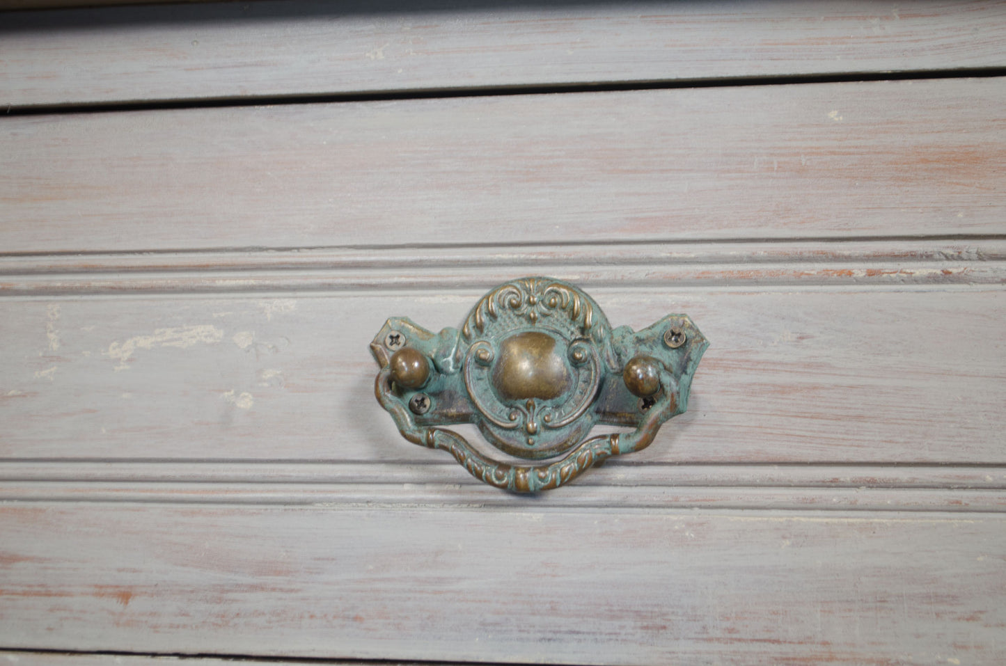 Decorative metal handle on a wooden surface