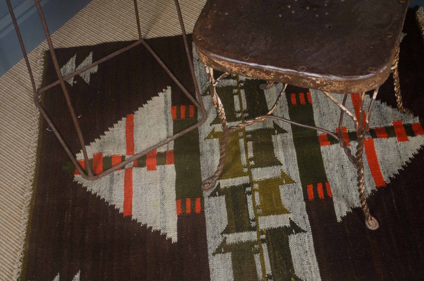 Two wooden chairs on a patterned rug with geometric design