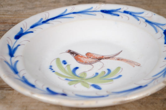 Vintage Quimper faience deep plate with hand-painted bird motif and blue decorative border on a white glazed ground.
