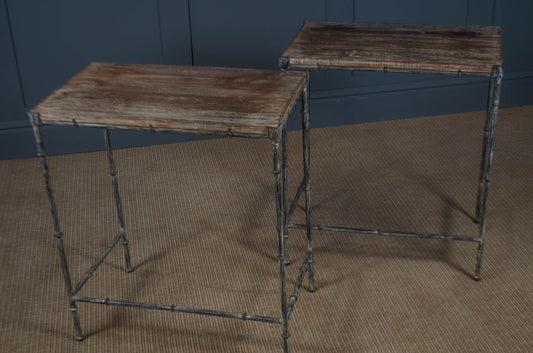 Two rustic wooden tables with metal frames on a textured floor against a blue wall.