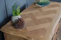 Wooden surface with a vase of greenery and a pine cone. Parquet top drawers