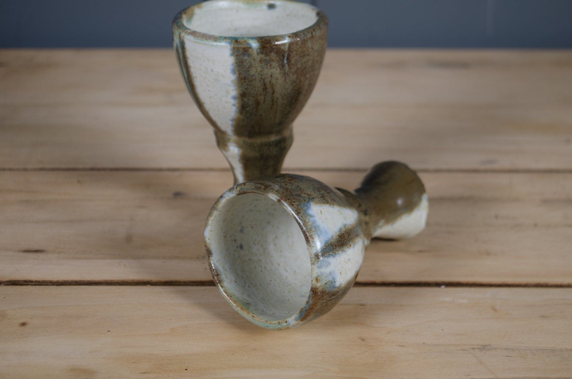 Set of two French hand-thrown pottery goblets with reactive sage green and white glaze.
