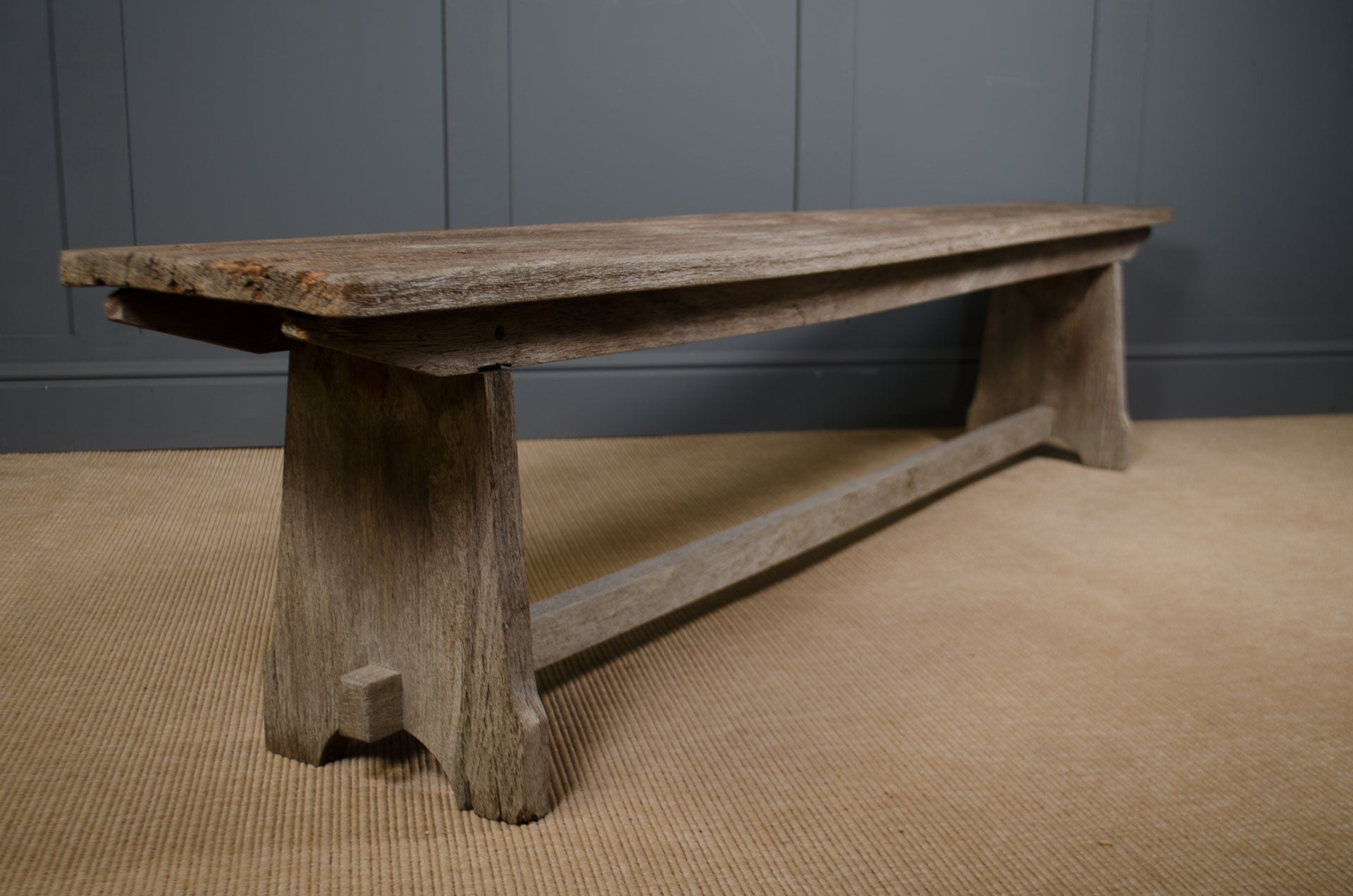 Rustic long oak bench styled in a hallway with vintage accessories