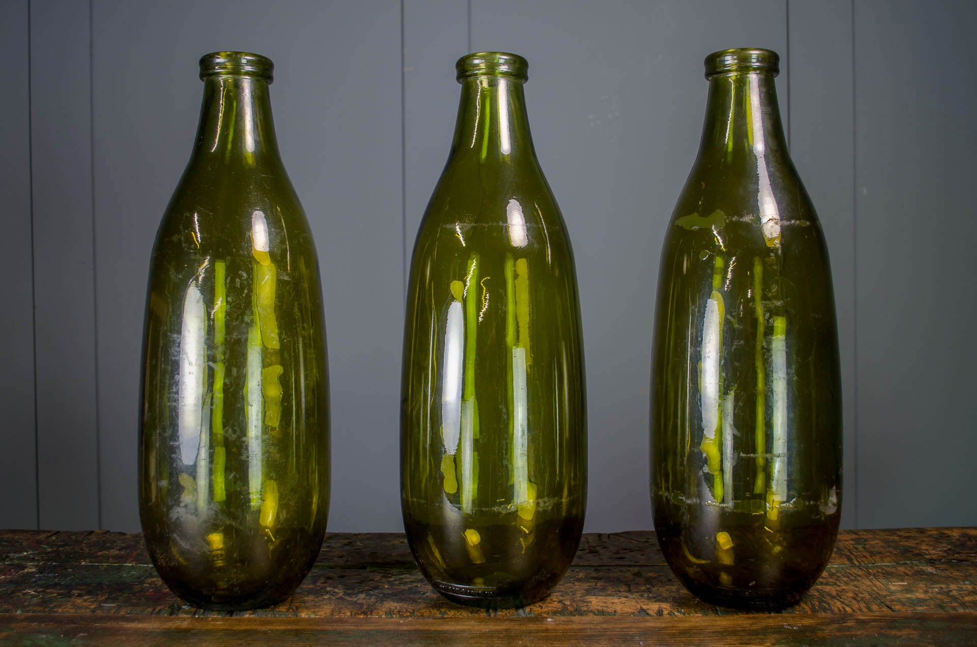 reclaimed french glass bottle in green, on a rustic farmhouse wood table