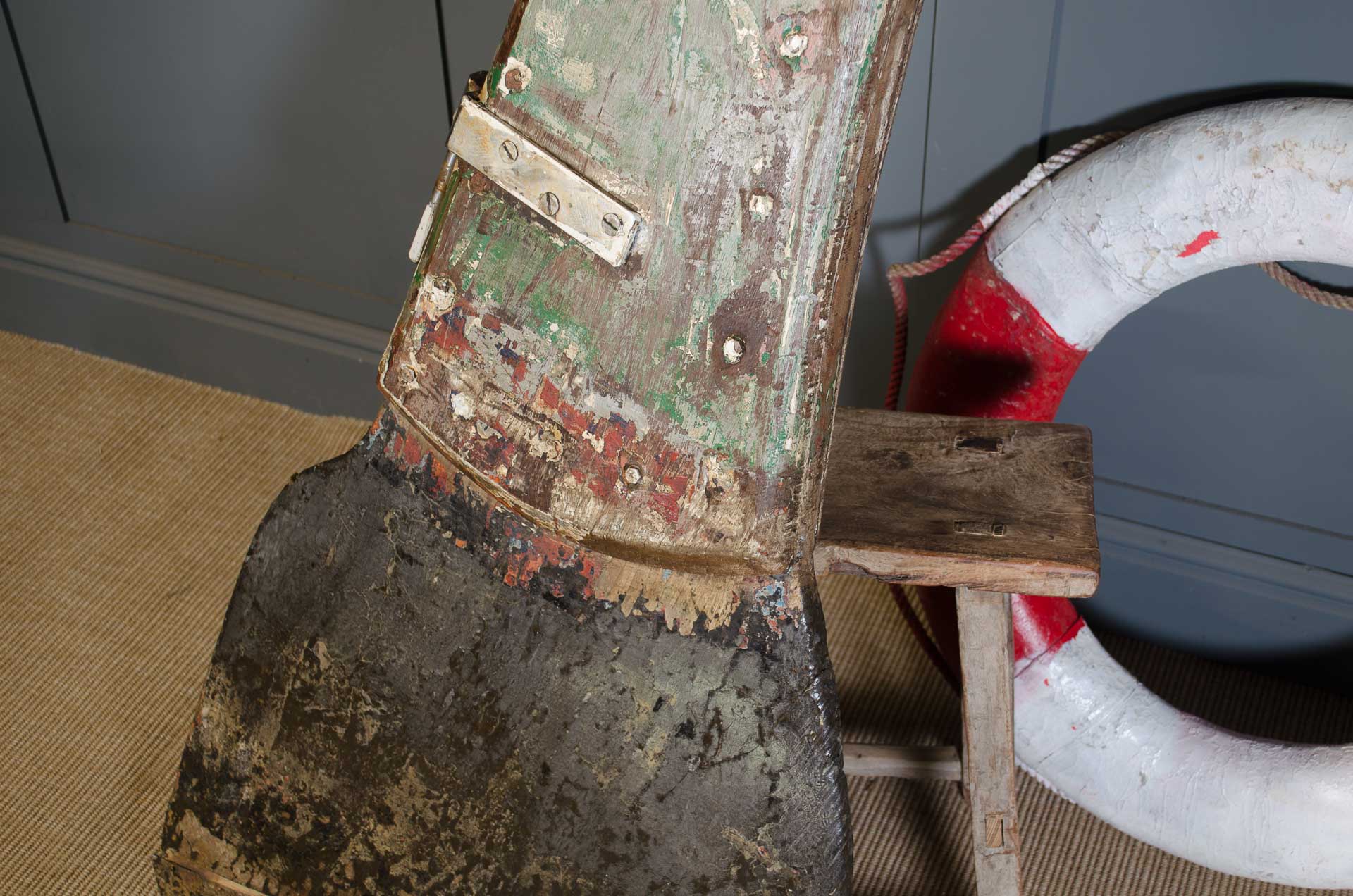 
Close-up of a worn-out boot with a life preserver in the background