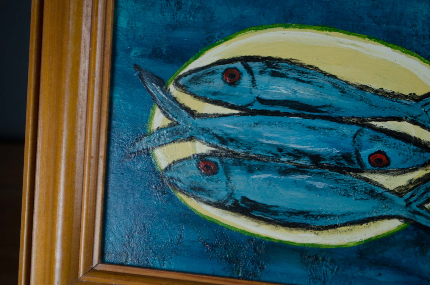 Framed three fish artwork with deep blue background