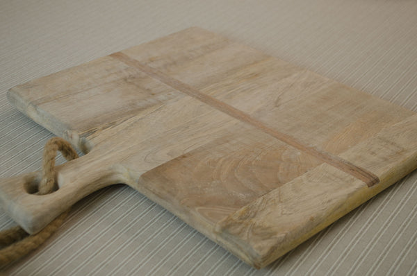 Mango wood serving board styled with cheese knife, butter and bread