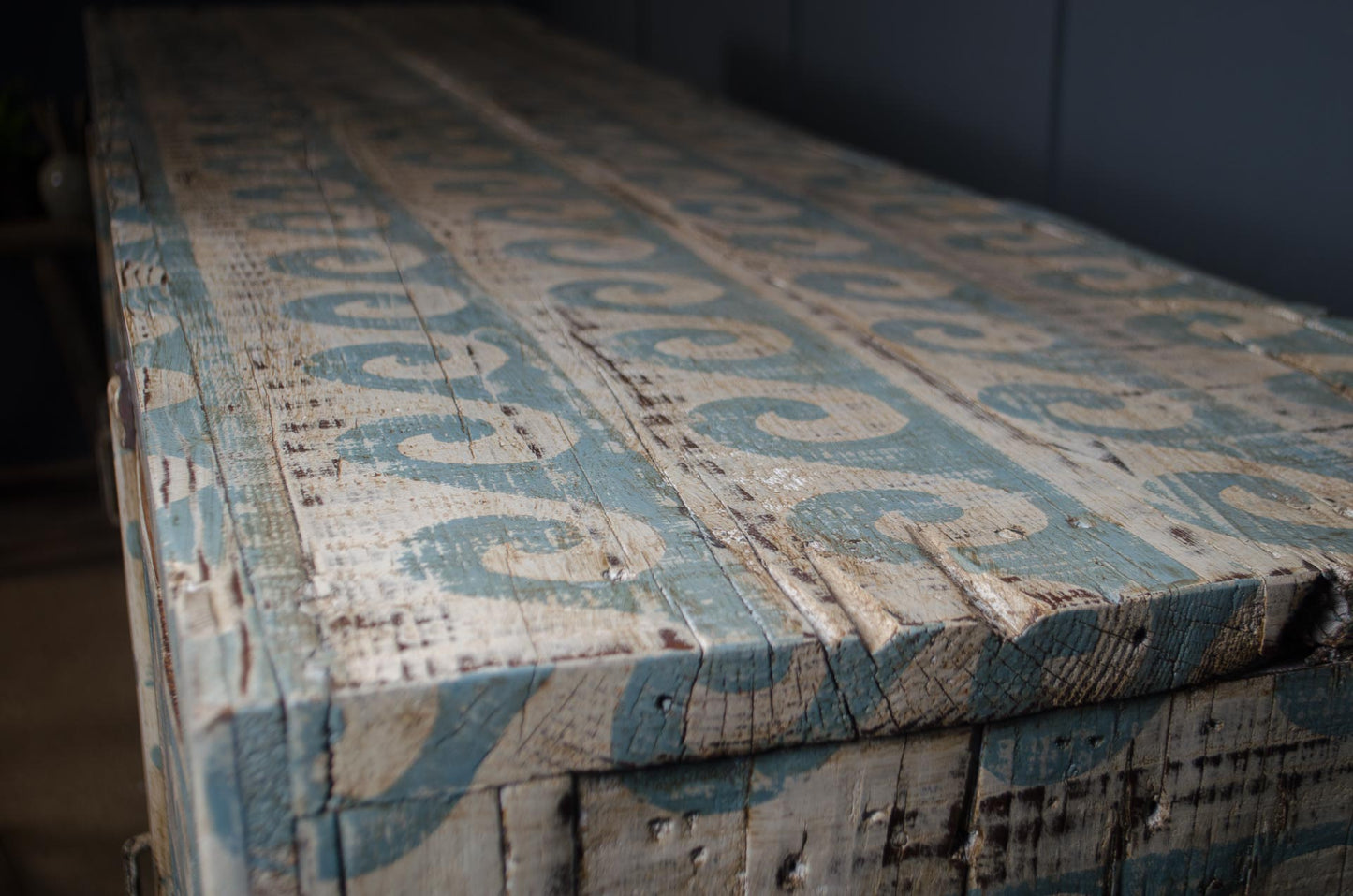 Decorative wooden box with intricate carvings and blue patterns on a dark background