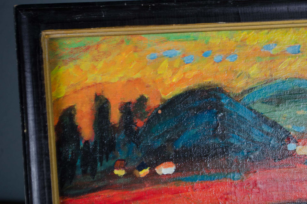 A close-up of a framed painting featuring an abstract landscape with a bright yellow and orange sky, dark blue hills, and red foreground, set in a black frame with a gold inner border.