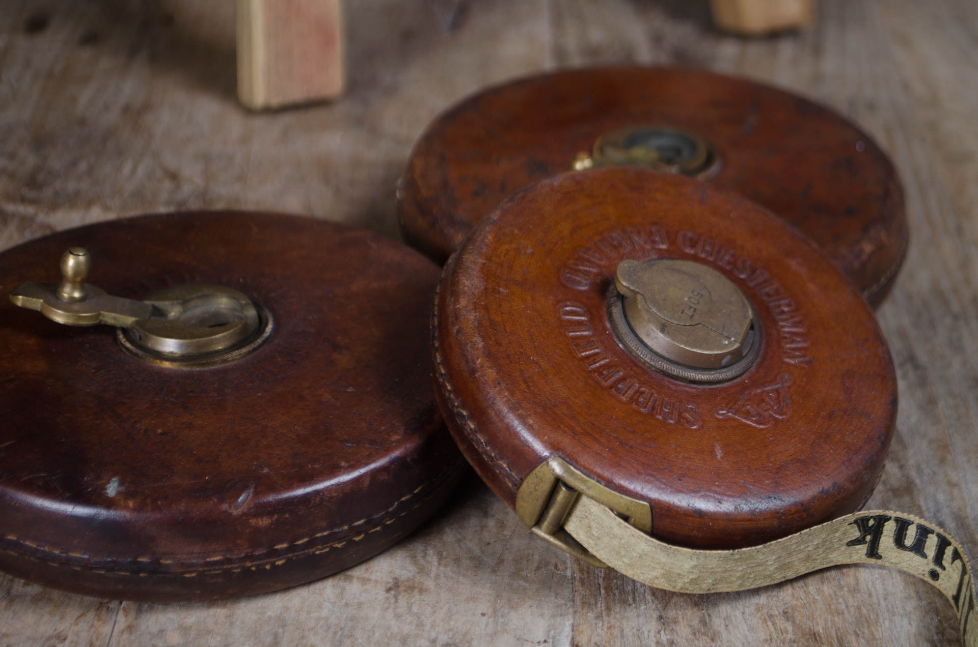 Antique measuring tape in round brown leather case.
