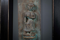 carved indian plaque with a seated figure on a dark background