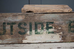 Weathered wooden crate with 'UTSIDE' branding on a gray background