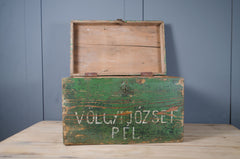 Vintage storage chest with faded green finish and travel destination lettering.
