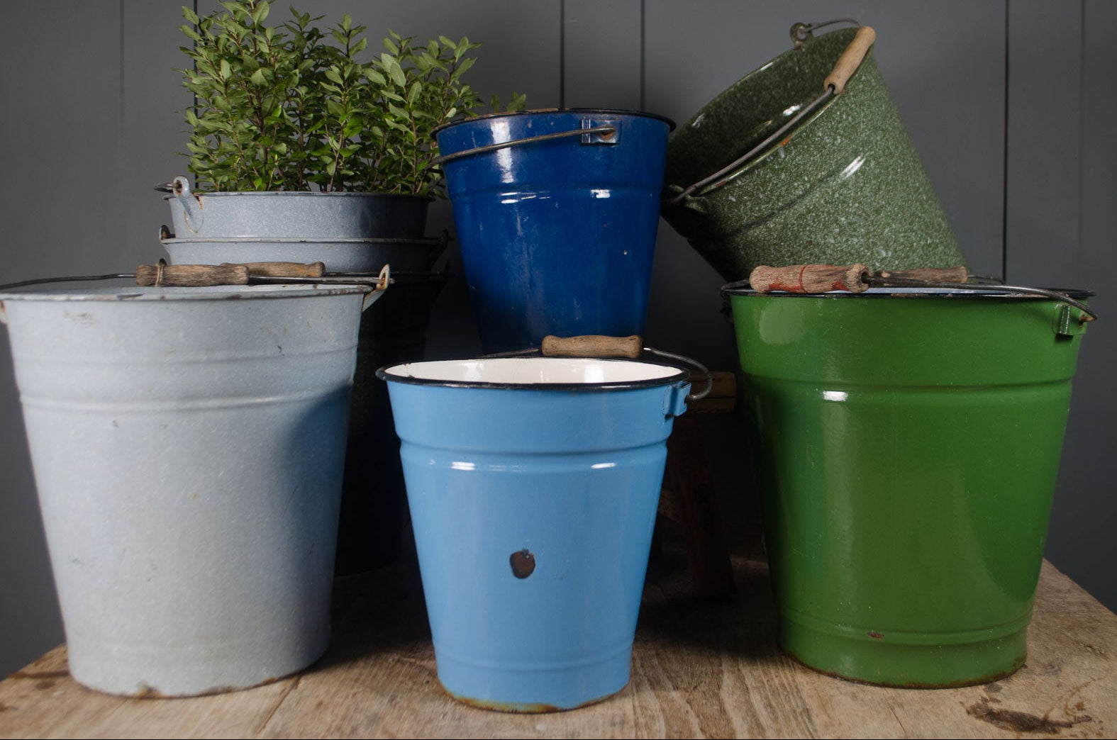 
Vintage enamel buckets with wooden handles in blue, green and white.