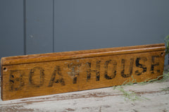 Wooden sign with 'BOATHOUSE' text on a gray background