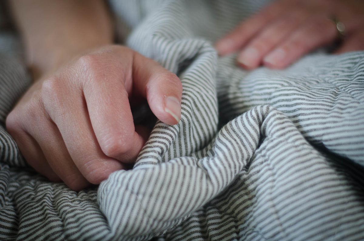 
Close-up of hands holding a striped blanket