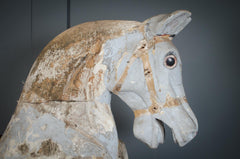 Vintage rocking horse with worn paint and freestanding wooden stand