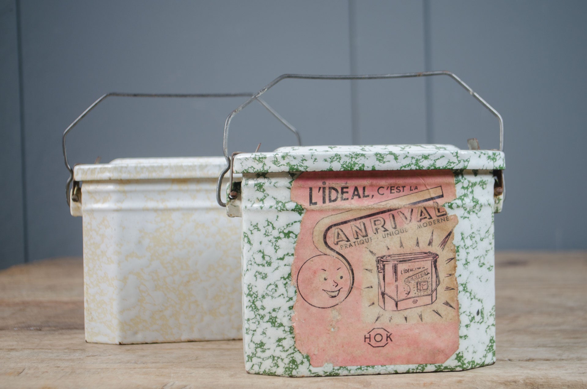
Vintage French enamel splatter lunch tin with original lid, wire handle and printed French label.
