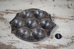 Vintage metal egg mold on a rustic wooden surface