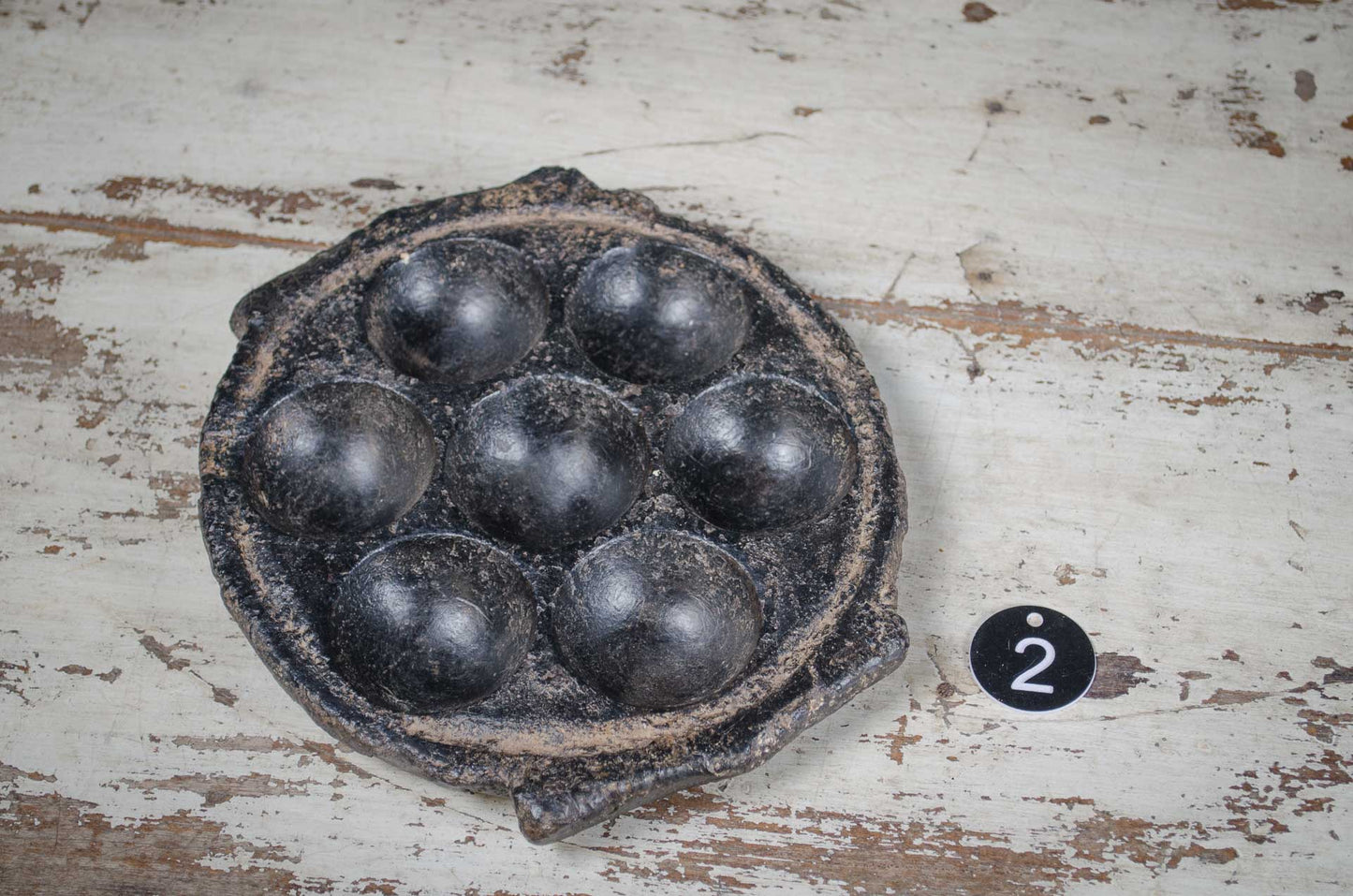 Vintage indian stone tealight holder metal objects on a rustic wooden surface