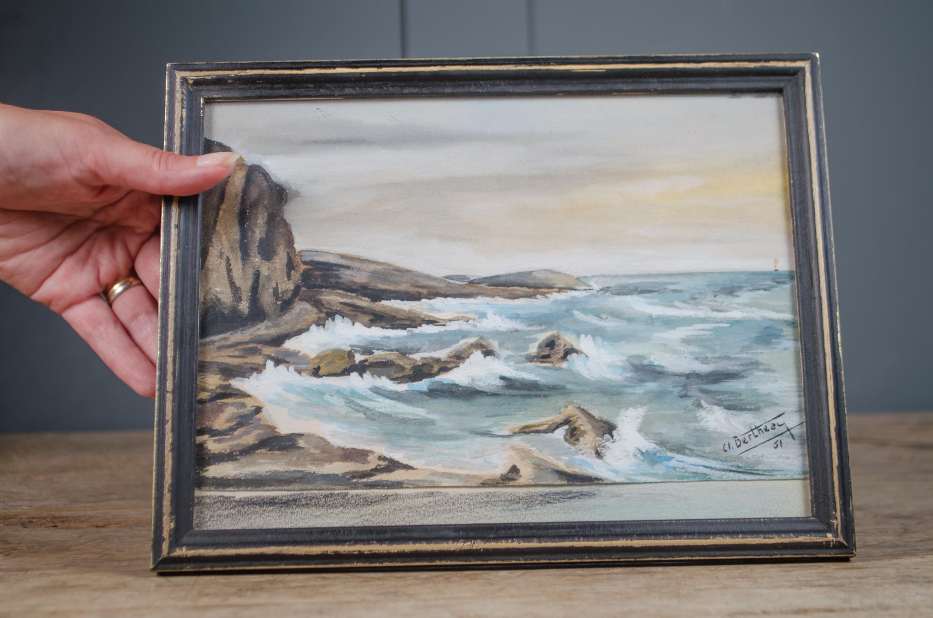 Vintage French coastal watercolour depicting waves breaking along a rocky shoreline in an ebonised and gilt painted frame.