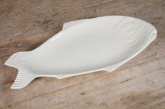 White fish-shaped platter plate on a wooden surface