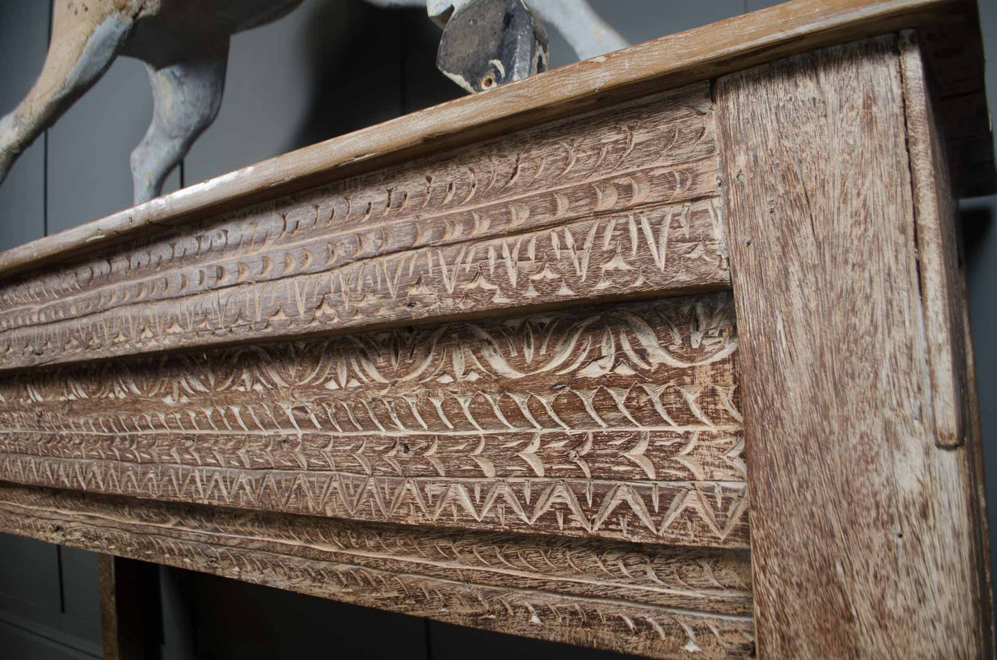 Decorative carved wooden console table with stretcher base and rustic patina